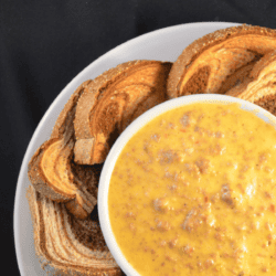CLose up image of rotel dip in a bowl with bread for dipping