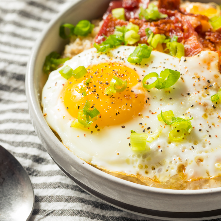 Close up image of savory oatmeal with bacon and a fried egg