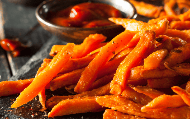 Close up image of sweet potato fries with a side of ketchup