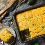 A pan of Mexican Cornbread with a plate of cornbread next to it - 8