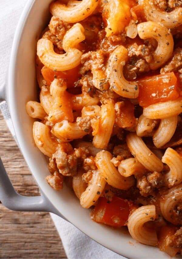 Close up of American Goulash in a white baking dish on a wooden cooking surface