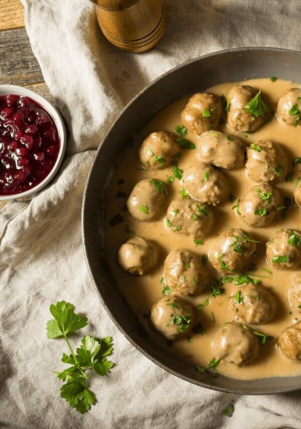 instant pot swedish meatballs in a pan with a side of lingonberry jam