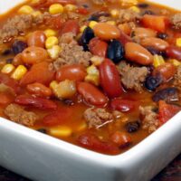 Close up image of Crockpot Taco Soup in a square white bowl