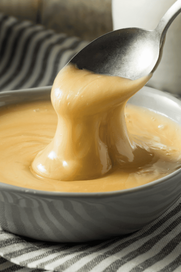 Maple Butter in a bowl being drizzled from a spoon