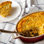Cheesy Corn Casserole with a serving removed and served on a plate - 8