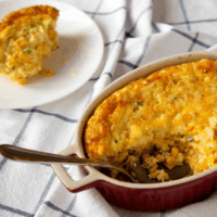 Cheesy Corn Casserole with a serving removed and served on a plate