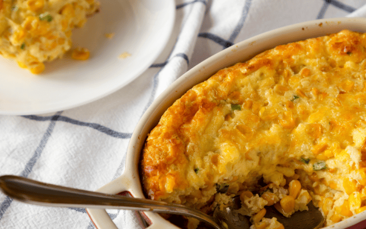 Cheesy Corn Casserole with a serving removed and served on a plate