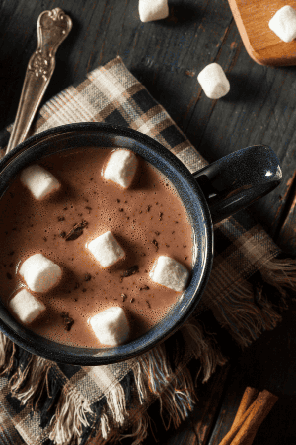 Overhead image of crockpot hot chocolate in a coffee mug with marshmallows