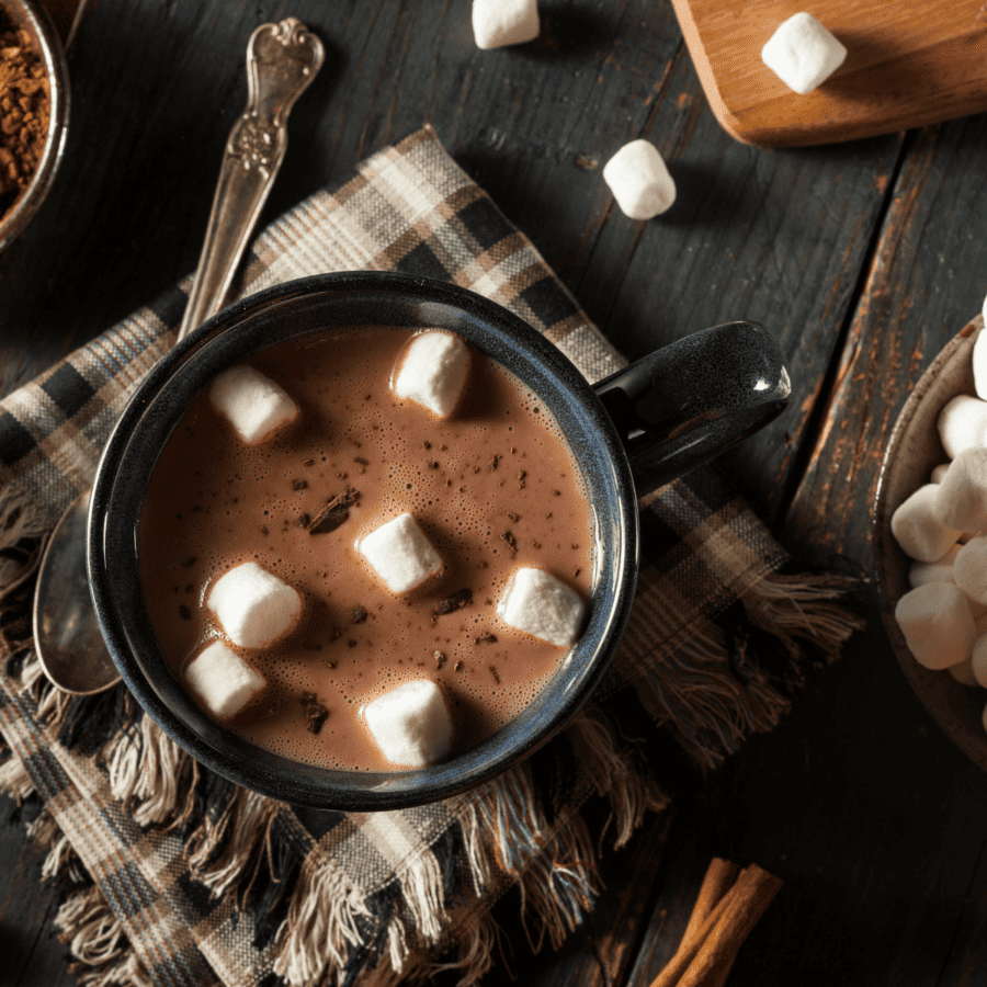 Overhead image of crockpot hot chocolate in a coffee mug with marshmallows