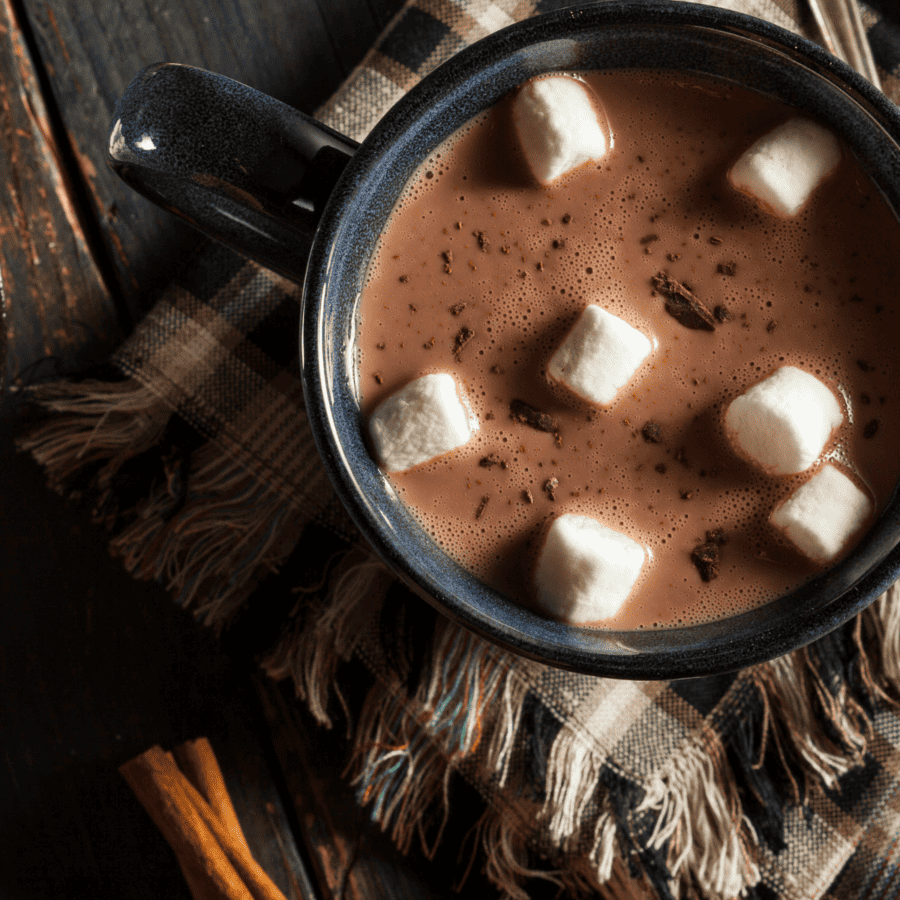 Close up image of crockpot hot chocolate in a blue mug with marshmallows