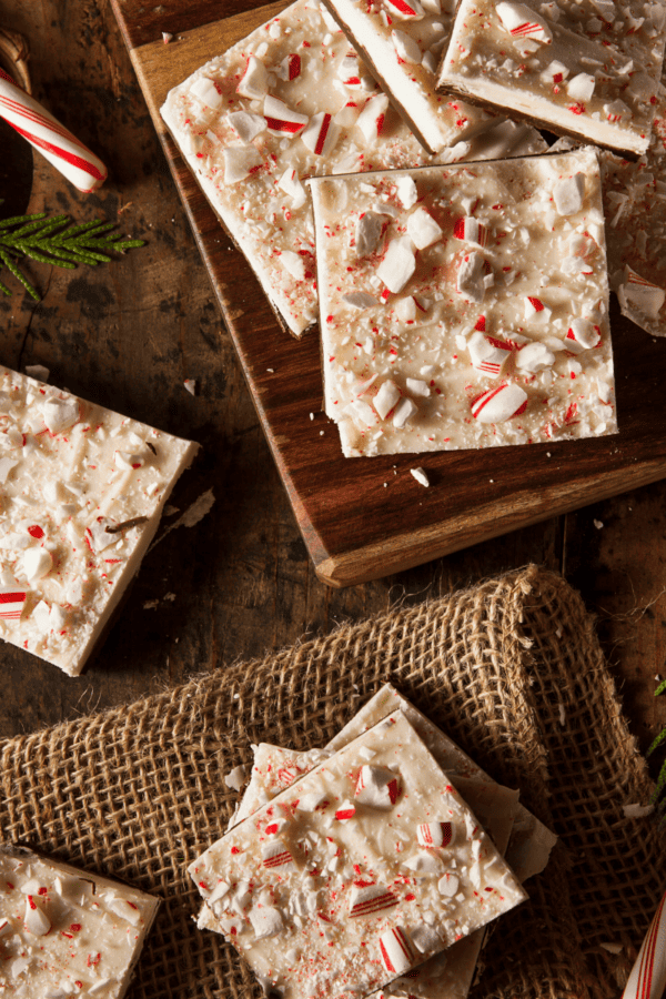Pieces of Peppermint Bark on a wooden and burlap surface