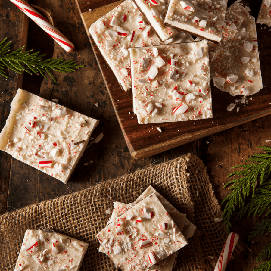 Pieces of Peppermint Bark on a wooden and burlap surface