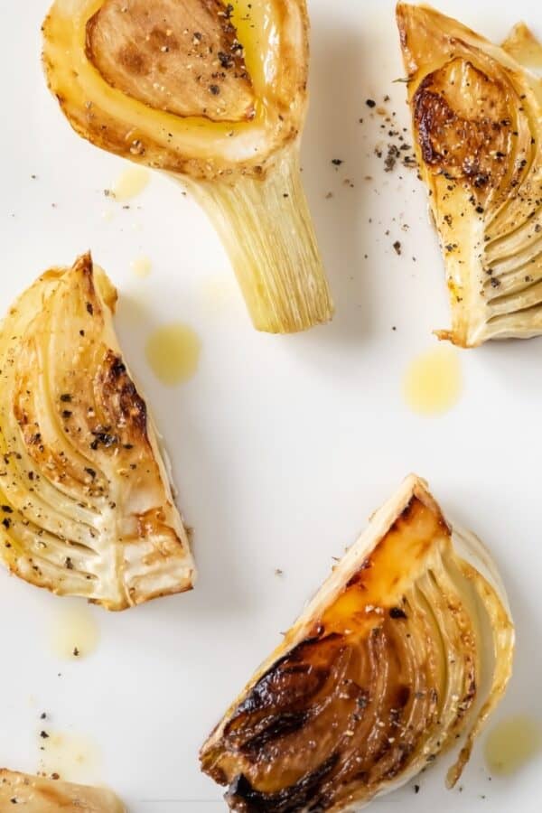 Overhead image of roasted fennel on a white serving tray