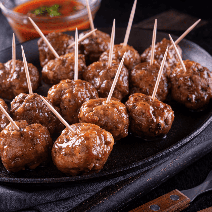 Cocktail Meatballs on a black plate with toothpicks inserted
