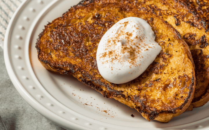 close up image of eggnog french toast on a white plate