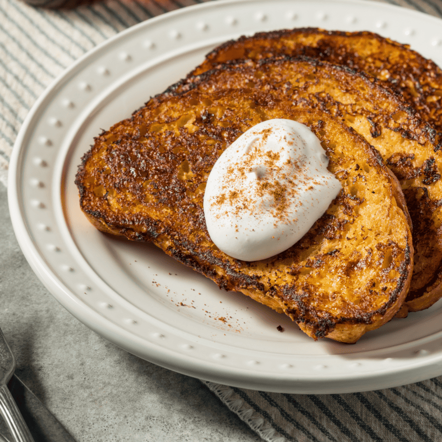 close up image of eggnog french toast on a white plate