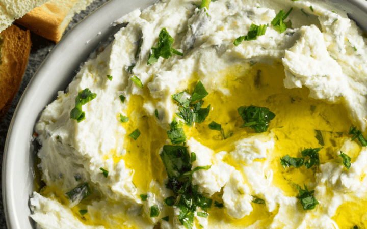 Close up image of whipped feta dip drizzled with olive oil