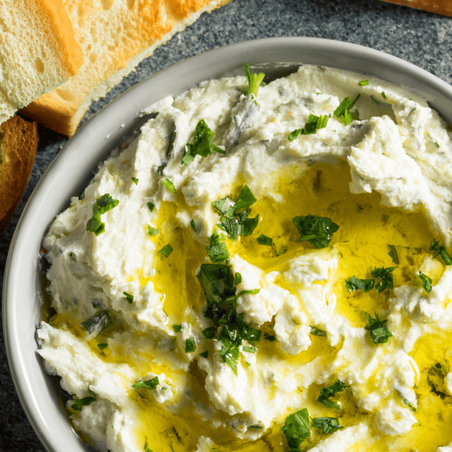 Close up image of whipped feta dip drizzled with olive oil