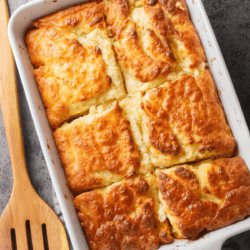 Overhead image of Butter Swim Biscuits in a rectangular pan with a wooden spatula