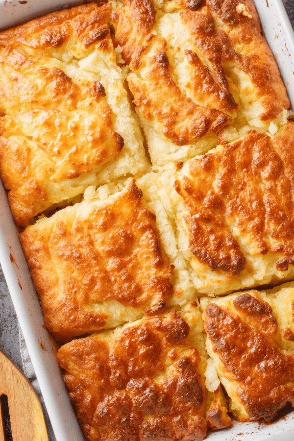 Overhead image of Butter Swim Biscuits in a rectangular pan with a wooden spatula
