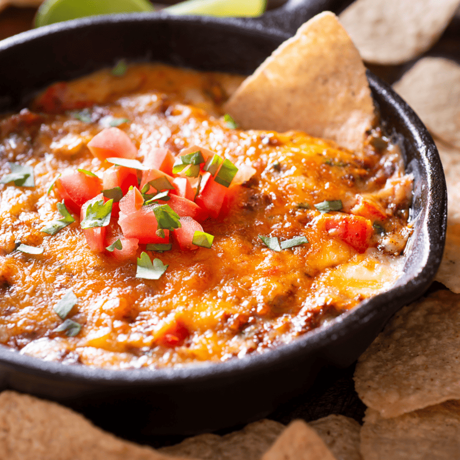 Skillet queso in a cast iron skillet with a side of corn tortilla chips