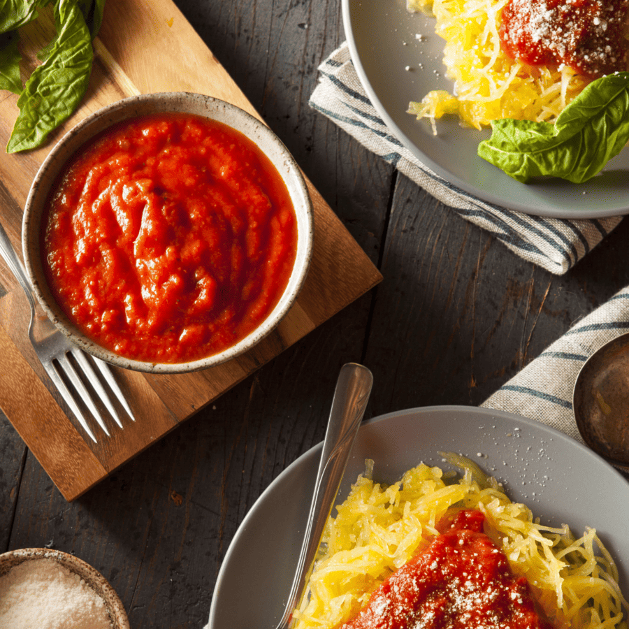 two plates of spaghetti squash casserole with a side of marinara squash