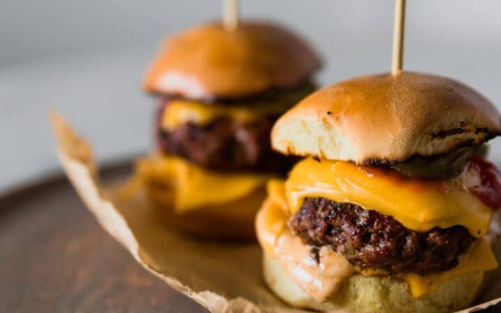Two Cheeseburger Sliders on parchment paper
