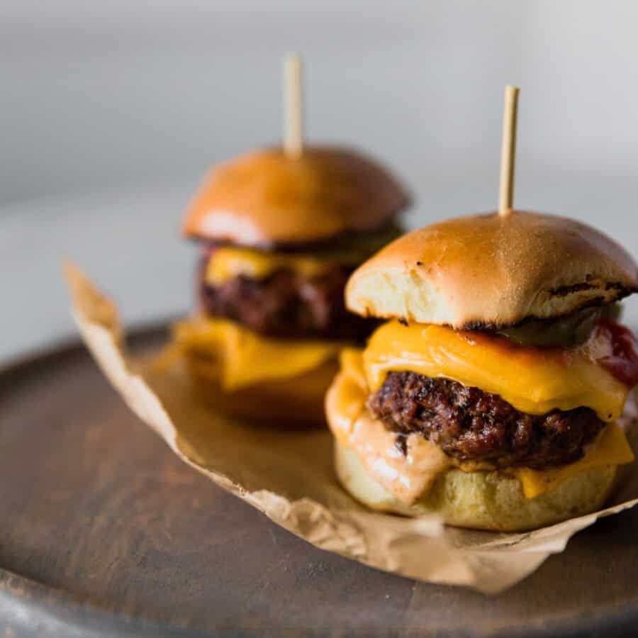 Two Cheeseburger Sliders on parchment paper