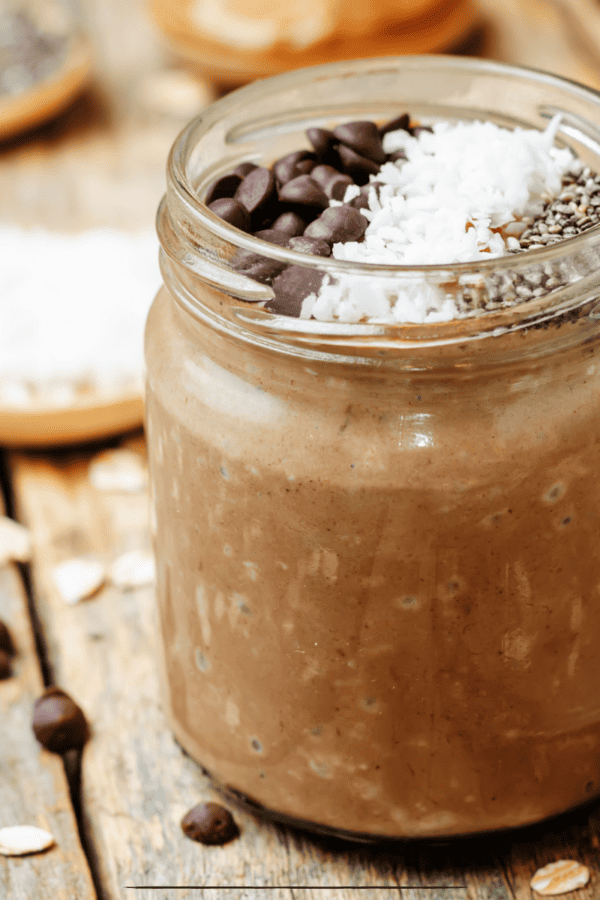 Mason jar of Chocolate Overnight Oats on a wooden table