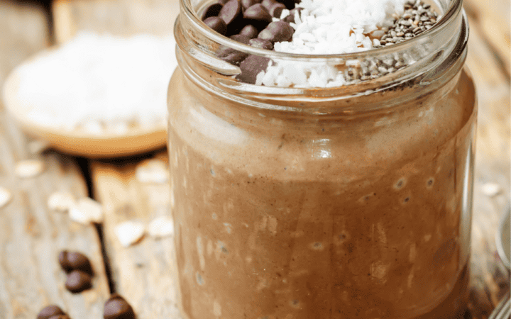 Mason jar of Chocolate Overnight Oats on a wooden table