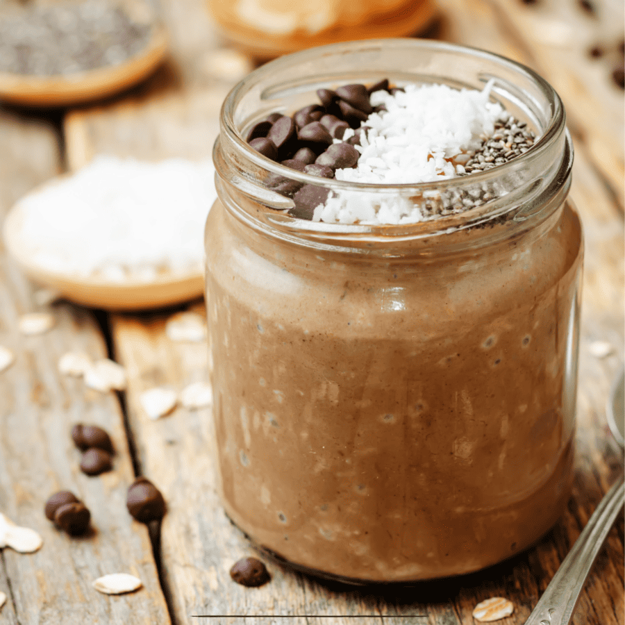 Mason jar of Chocolate Overnight Oats on a wooden table 
