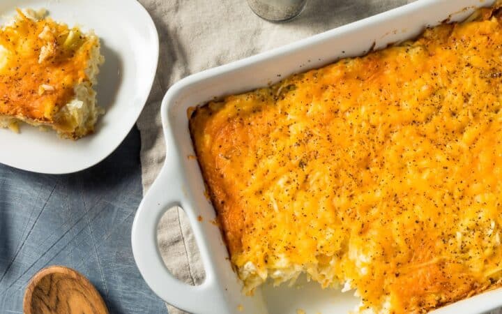Overhead image of hashbrown casserole in a baking dish with a plate next to it