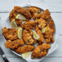 overhead image of parmesan crusted chicken with lemon garnish