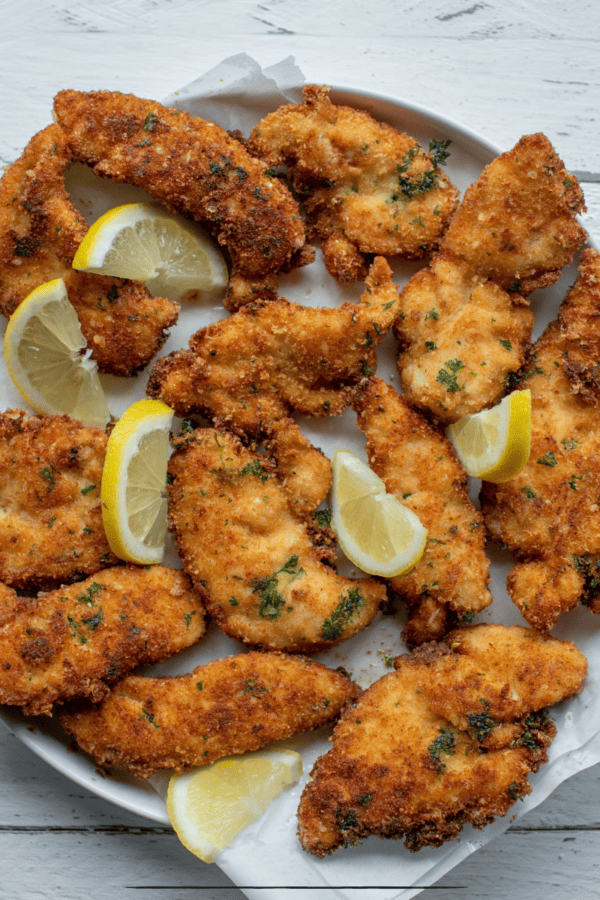 overhead image of parmesan crusted chicken with lemon garnish