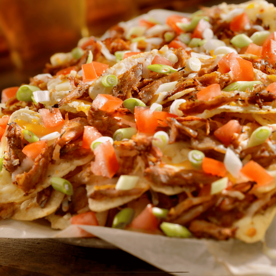 Pulled Pork Nachos on a parchment paper lined baking sheet