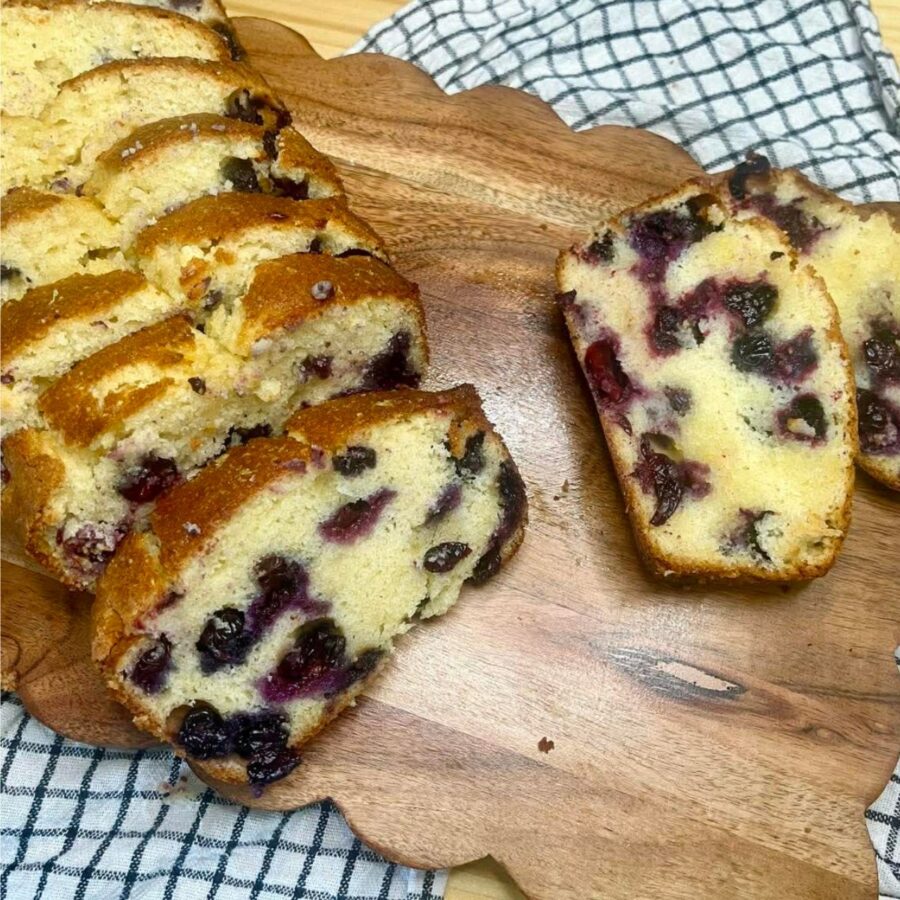 Overhead image of blueberry loaf cake sliced on a serving tray