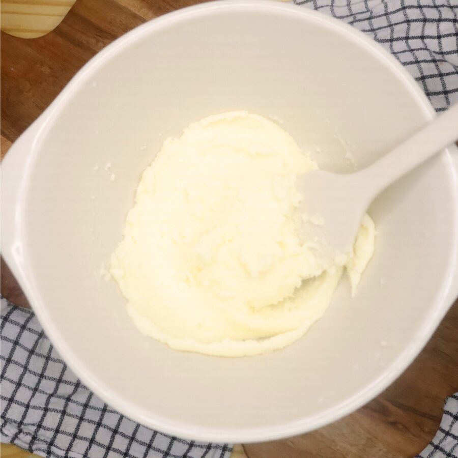 Creamed butter and sugar in a bowl with a silicone spatula
