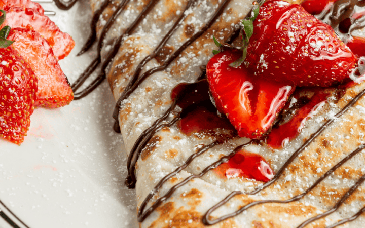 Sweet Breakfast Crepes drizzled with chocolate and topped with strawberries