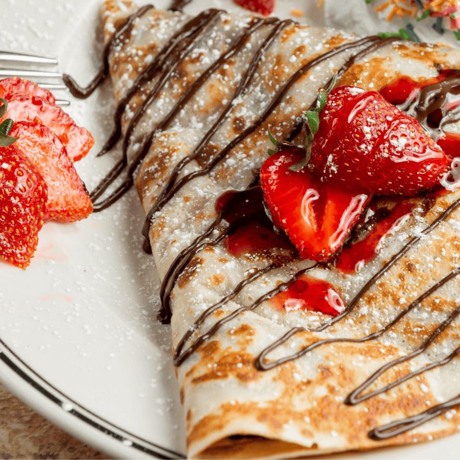 Sweet Breakfast Crepes drizzled with chocolate and topped with strawberries