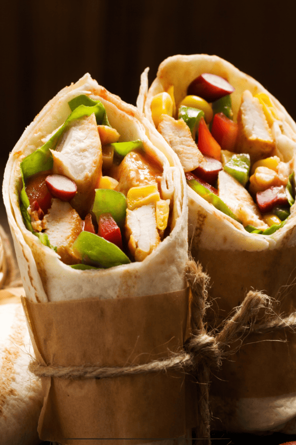 An assortment of grilled chicken wraps cut diagonally standing on their end