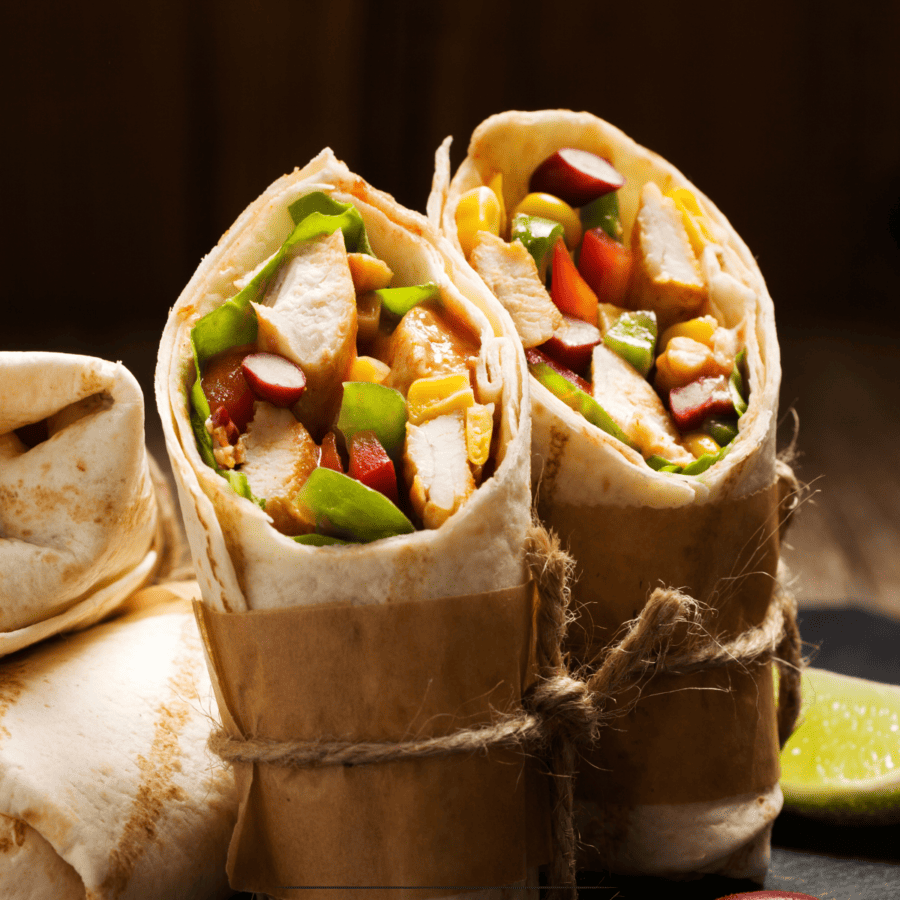 An assortment of grilled chicken wraps cut diagonally standing on their end
