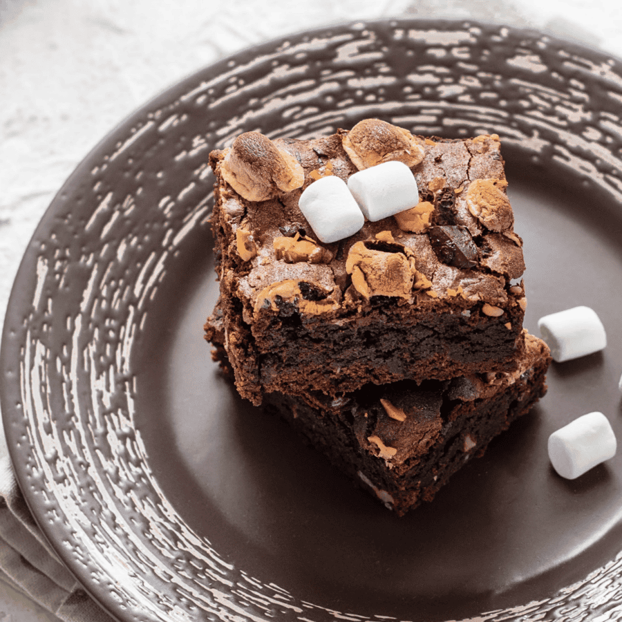 Close up image of S'mores Brownies on a plate with loose marshmallows