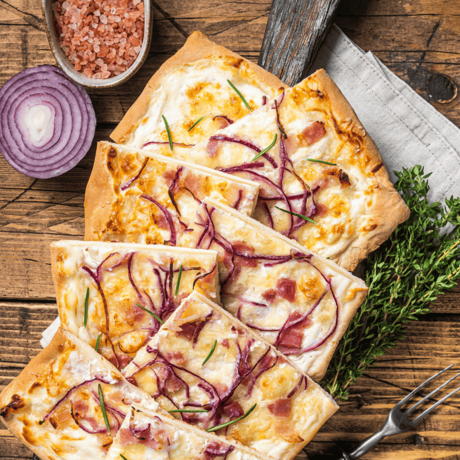 overhead image of a tarte flambee cut into pieces