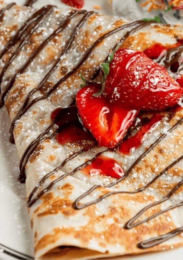 Sweet Breakfast Crepes drizzled with chocolate and topped with strawberries