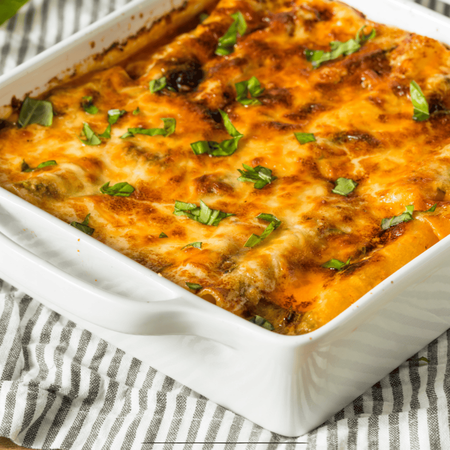 Chicken lasagna in a white baking dish on a striped cloth