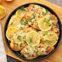 Overhaed image of Chicken Piccata on a black plate