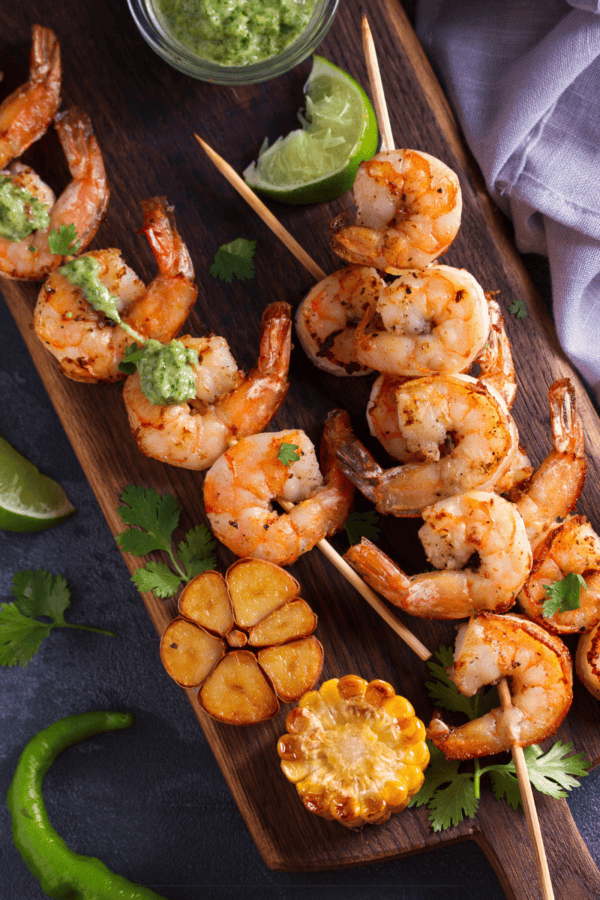 Cilantro Lime Shrimp on skewers laying on a wooden cutting board
