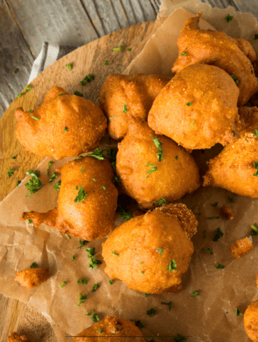 Overhead image of hush puppies on parchment paper with dipping sauce