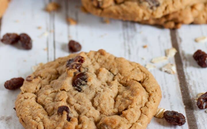 Close up image of Oatmeal Raisin Cookies with raisins sprinkled around them
