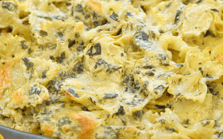 Close up image of Spinach Artichoke Pasta in a baking dish